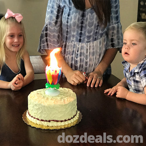 Lotus musical birthday candle on a cake with boy and girl watching.